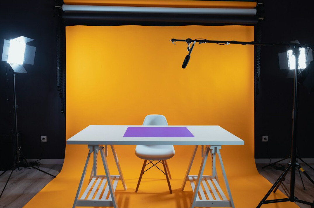 News presenters seated at a television studio desk under broadcast lighting